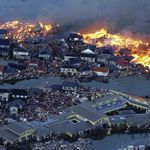 Houses are in flame while the Natori river is flooded over the surrounding area by tsunami tidal waves in Natori city, Miyagi Prefecture, northern Japan, March 11, 2011, after strong earthquakes hit the area. 